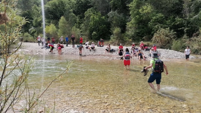 Los participantes en la Marcha a Canal Roya cruzan el río Alcanadre.