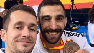 Juan Gordo muestra feliz su medalla junto a su entrenador.