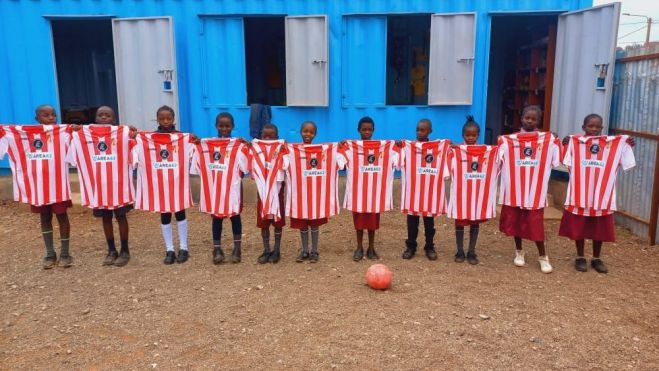 Los niños posan enseñando la camiseta rojiblanca del Barbastro